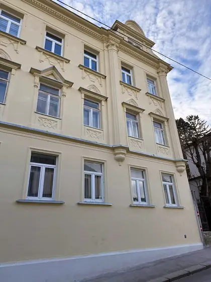 Dieselbe Altbaufassade in Wien nach der Sanierung durch emasan